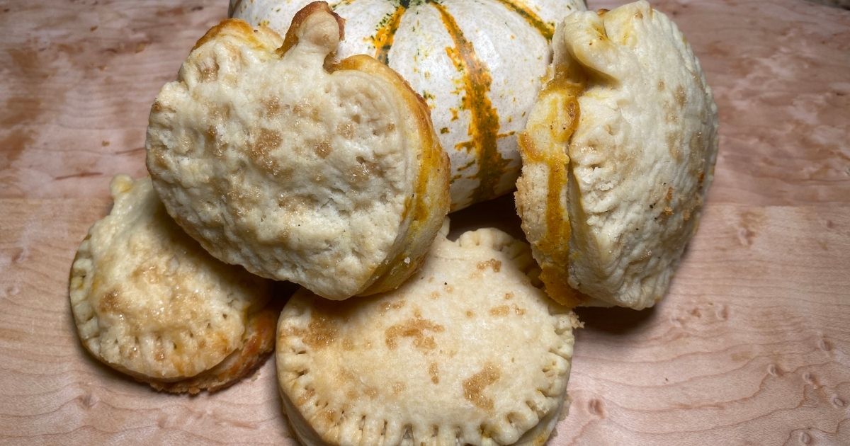 Sugar Crusted Pumpkin Harvest Hand Pies stacked next to a pumpking