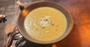 Broccoli Brie Soup in a bowl with thyme garnish