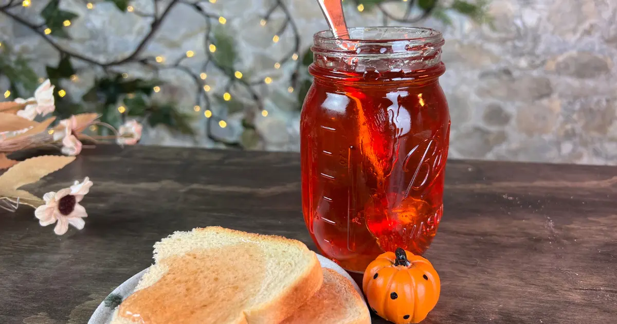 apple jelly in a jar behind a slice of toast