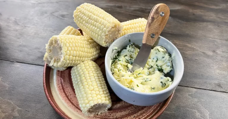 Sweet corn on a plate with a bowl of butter