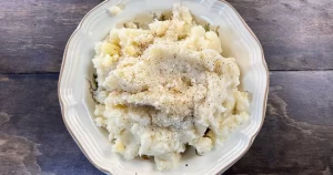 Hobbit's Mashed Potatoes sitting on a plate, topped with fresh ground black pepper