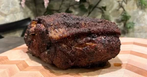 Crispy Baked Pork Shoulder Butt Roast sitting on a cutting board